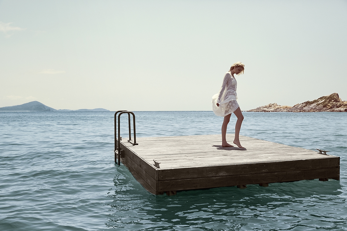 Summer Swim 16 Campaign image of Lily Donaldson stood on a jetty in the ocean 