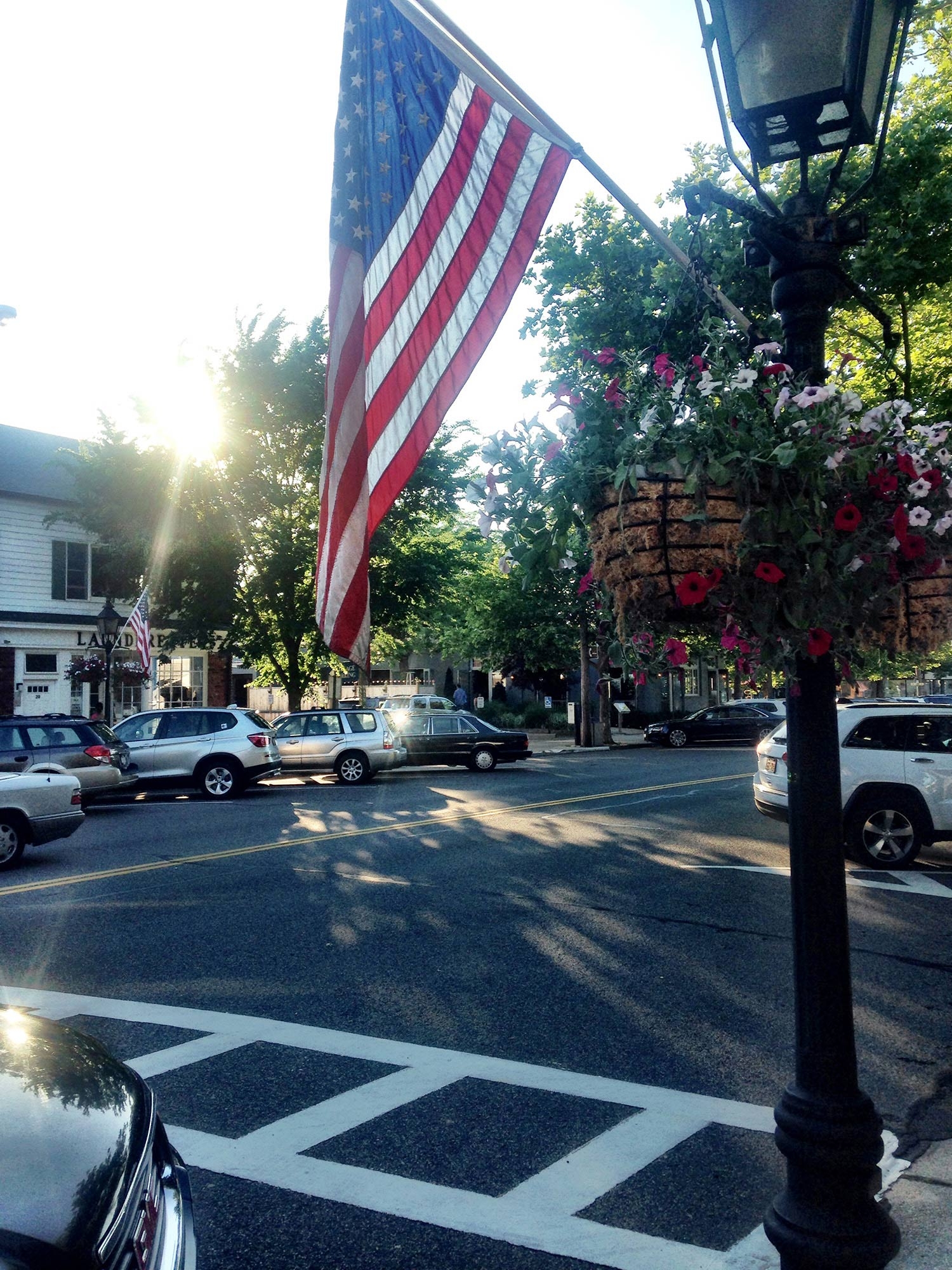 The American flag hanging from a pole on a street in East Hampton 