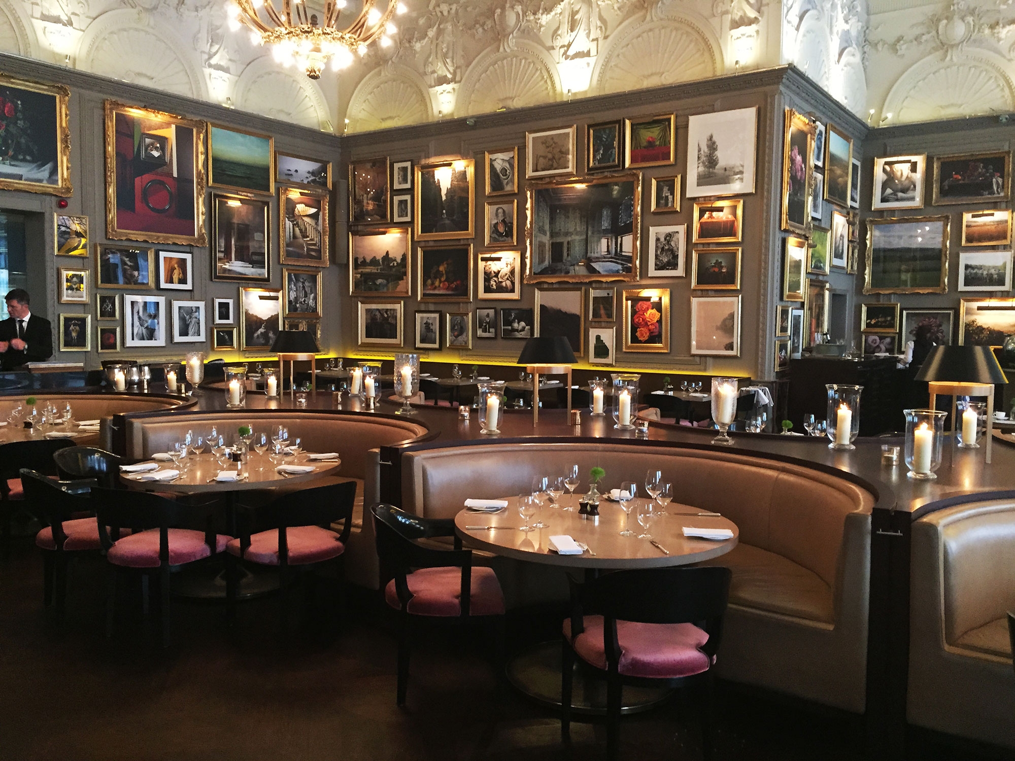 The interior of Berners Tavern contains framed pictures covering the walls and booth seating. June 2016