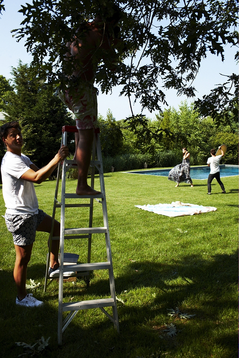 A behind the scenes shot of our 2009 Swim photoshoot – one man holds the bottom of a ladder while the other is stood at the top with his head in the trees 