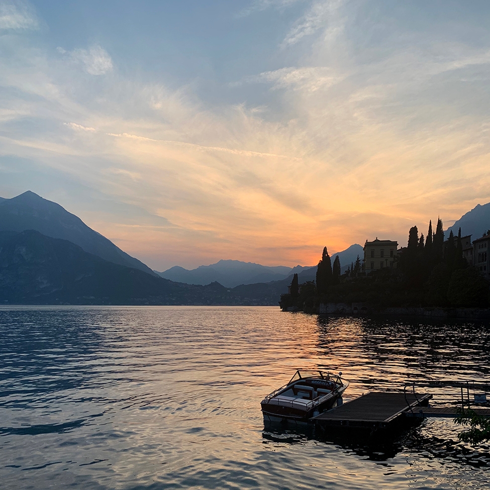 As the evening rolls in, the sun tucks itself behind a distant mountain and the vibrant orange hues reflect off Lake Como, creating a silhouette of the landscape. 