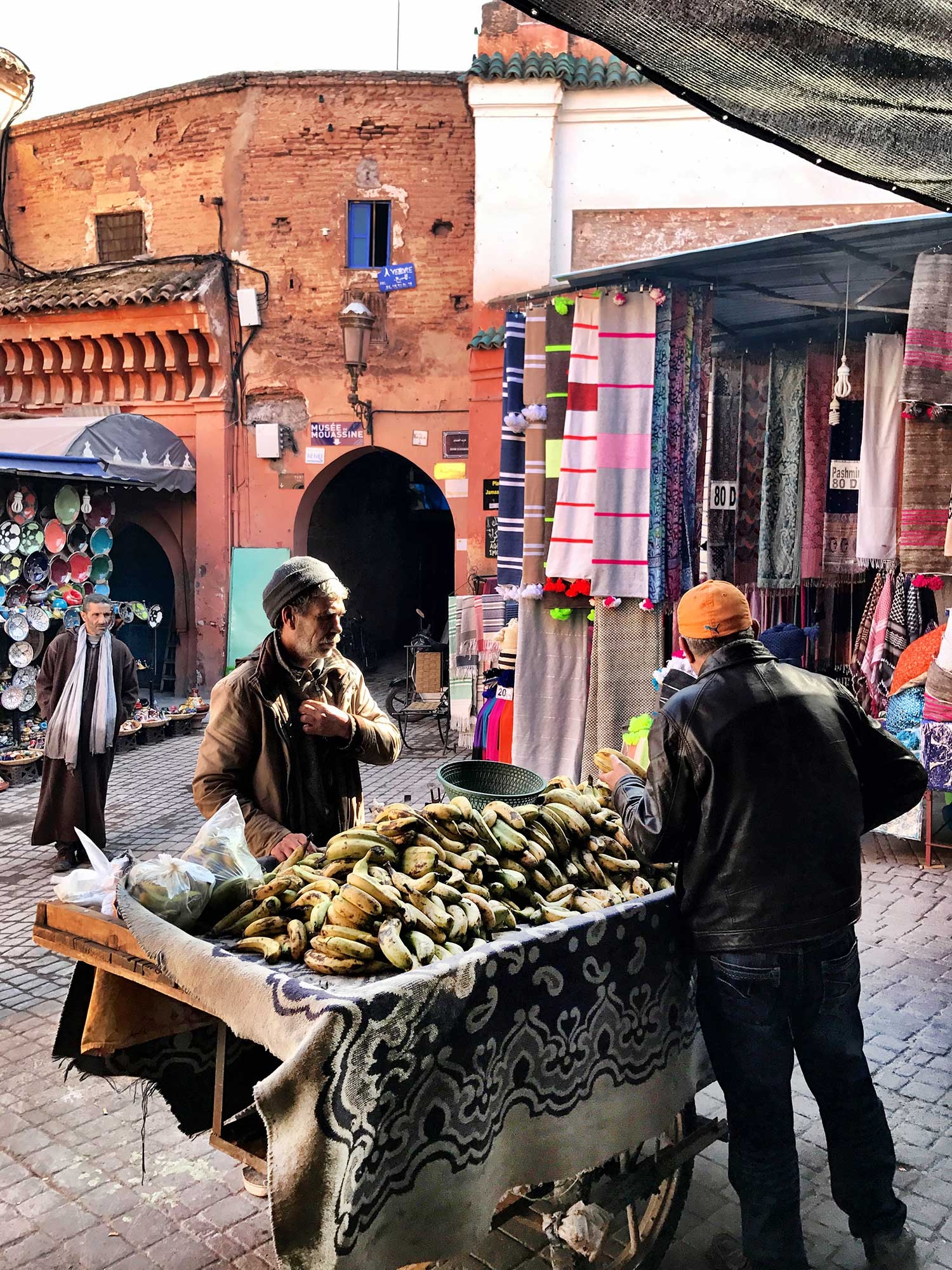 A man sells bananas on a large table in the laneways of the souks 